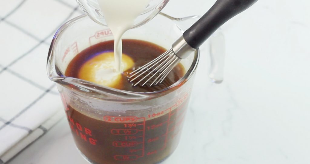 Adding a touch of heavy cream to hot caramel sauce.