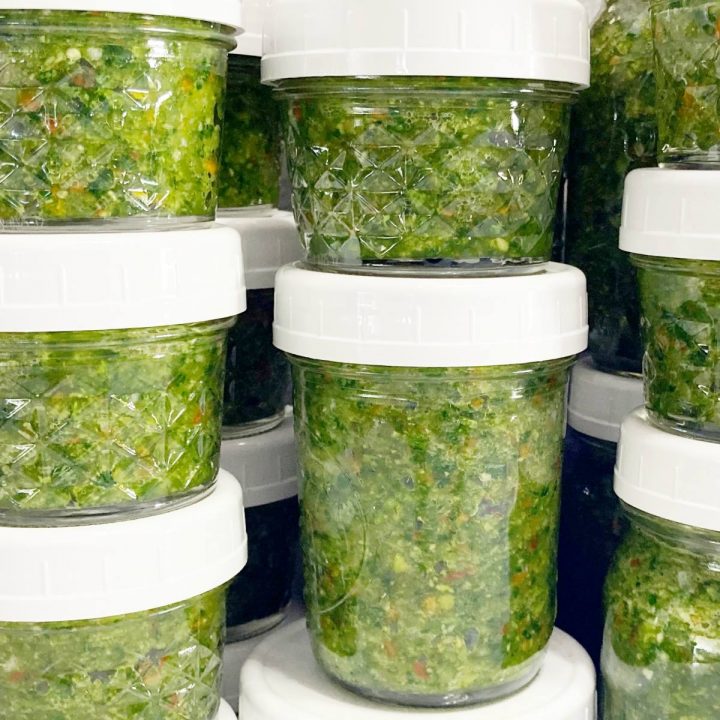 Large batch caribbean green seasoning in mason jars.