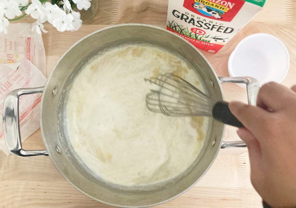 Mixing bechamel sauce after adding in milk.