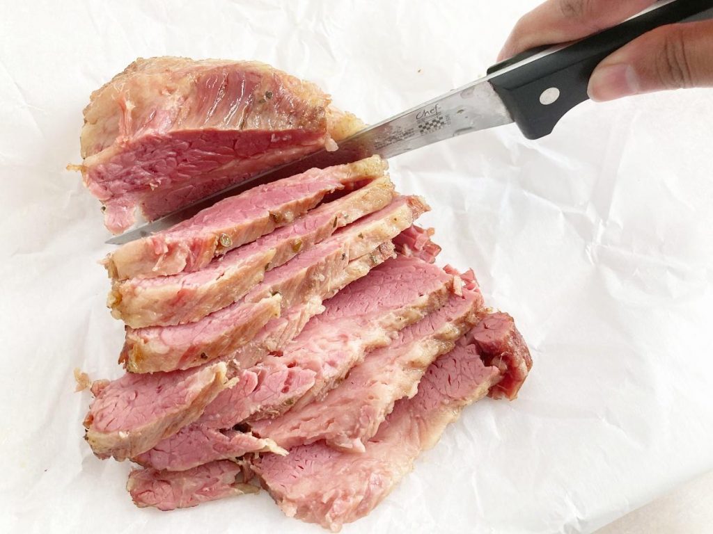 Slicing cornbeef with knife. Thick slices.