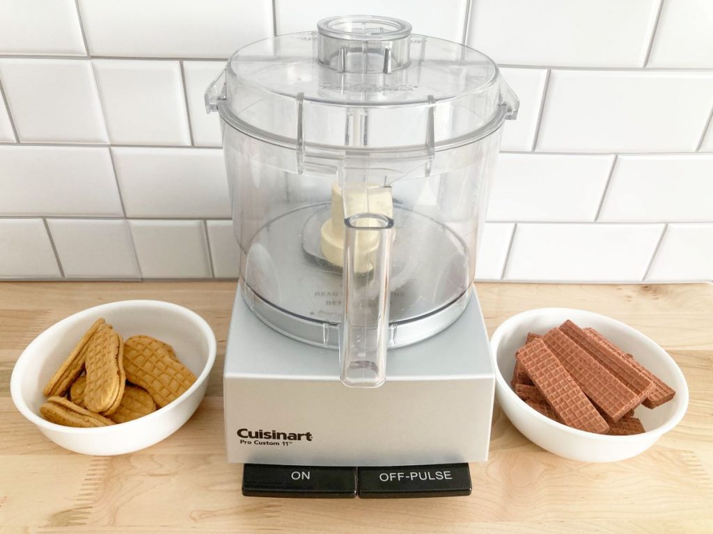 Food processor with two bowls of whole nutter butter and chocolate wafers.