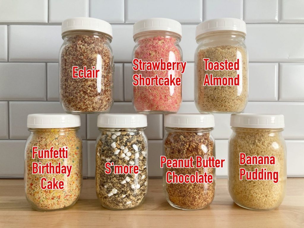 Seven mason jars filled with crunch toppings.