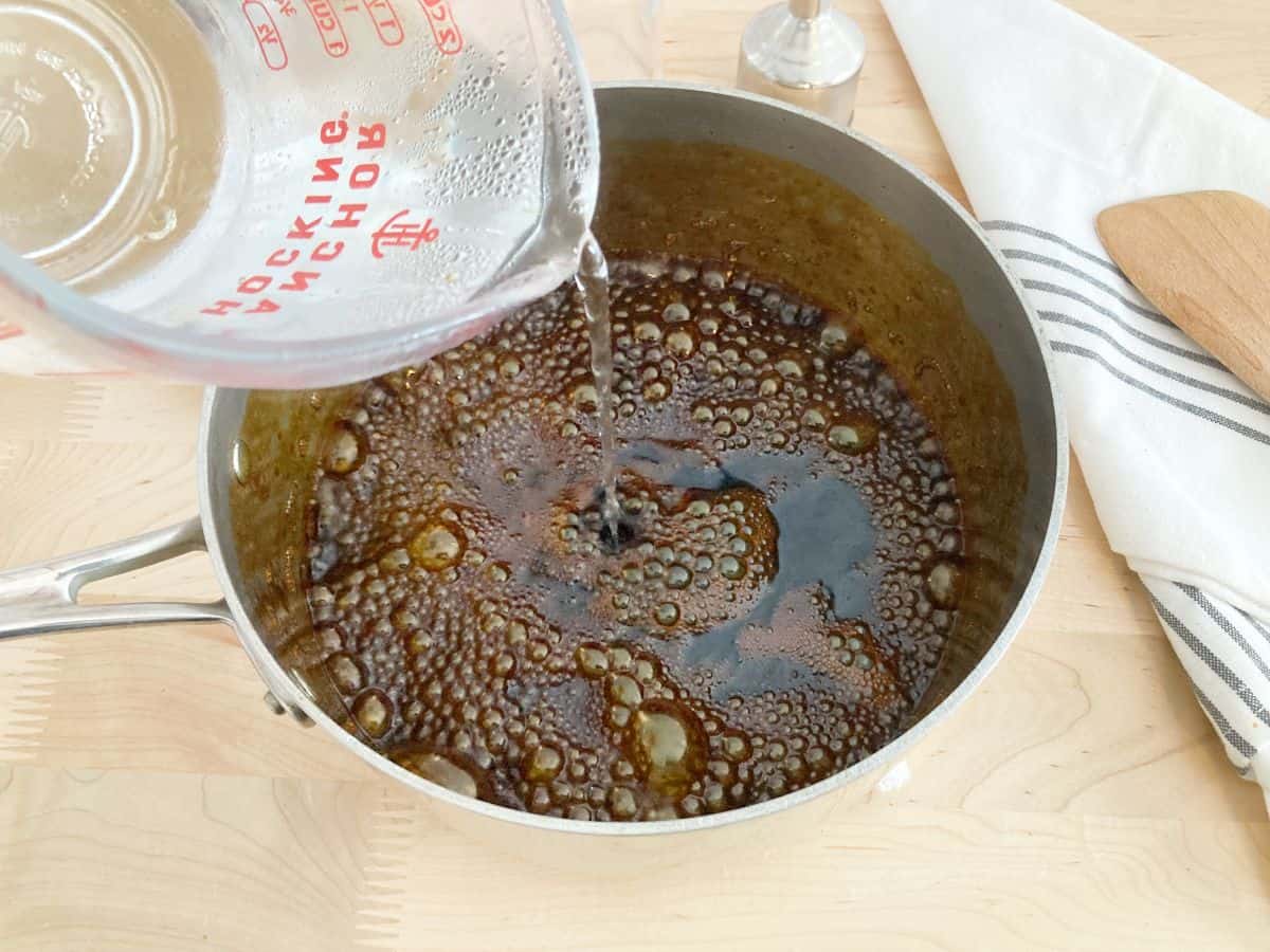 Adding hot water to bubbling darkened brown sugar.