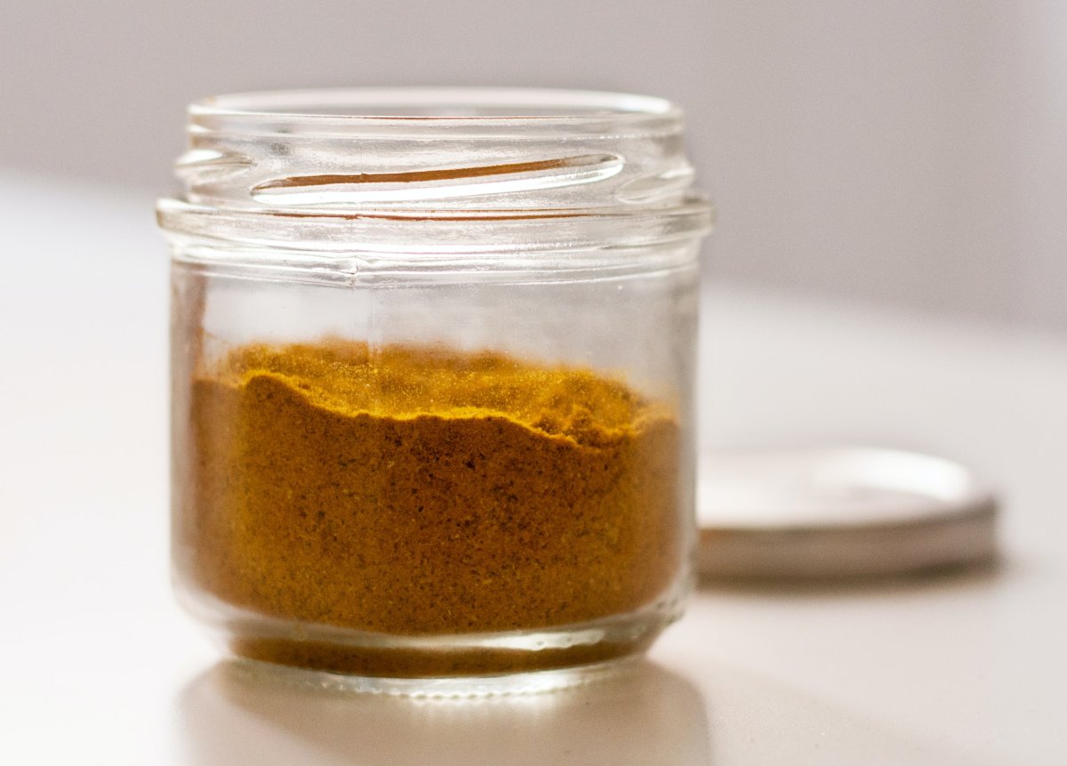 Curry powder blend in glass jar with white lid in background