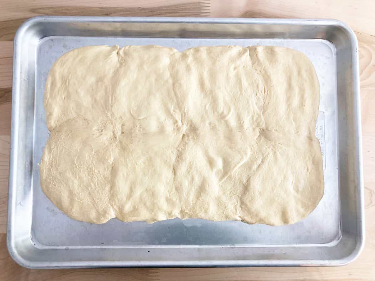 Biscuit dough that has been pinched together to from large rectangle.