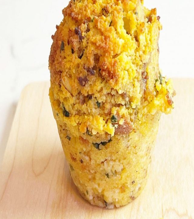Baked cornbread sausage stuffing muffins or Stuffin on light wood cutting board and marble background.