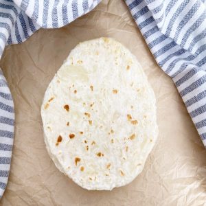 1 ingredient cassava tortilla recipe stacked on brown parchment paper.