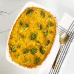 Tiktok knorr chicken broccoli rice casserole in white dish next to a gold serving spoon.