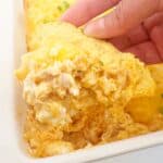 Hand holding a tortilla chip with the layered buffalo chicken dip.