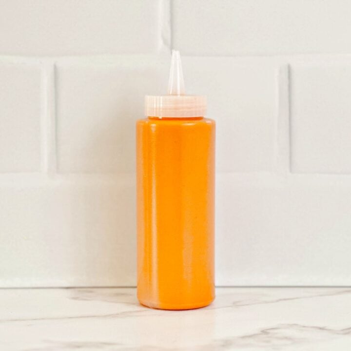 Side view of the restaurant style buffalo sauce in a squeeze bottle.