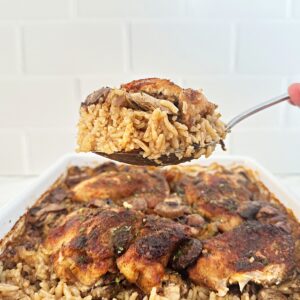 Serving spoon holding stick of butter rice and chicken.