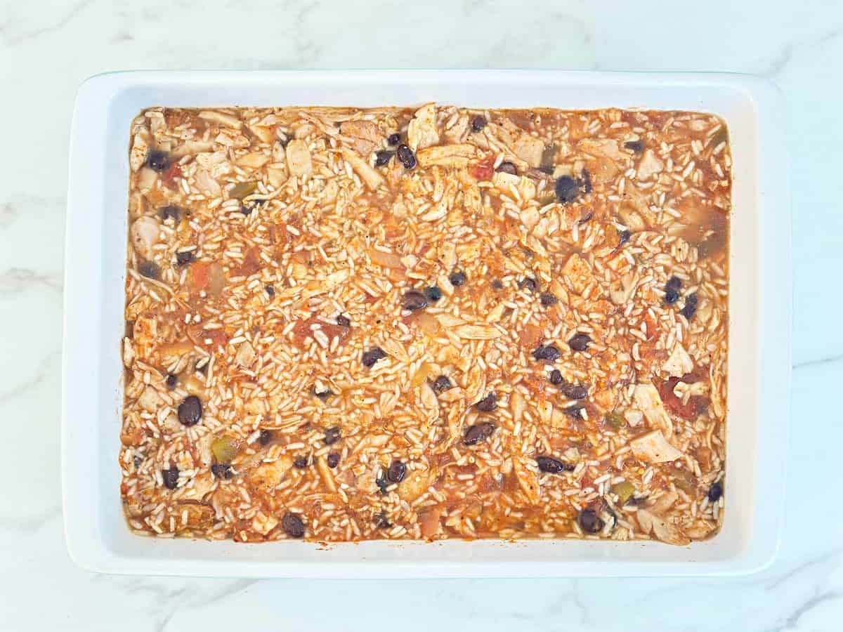 Down view white baking dish with unbaked casserole.