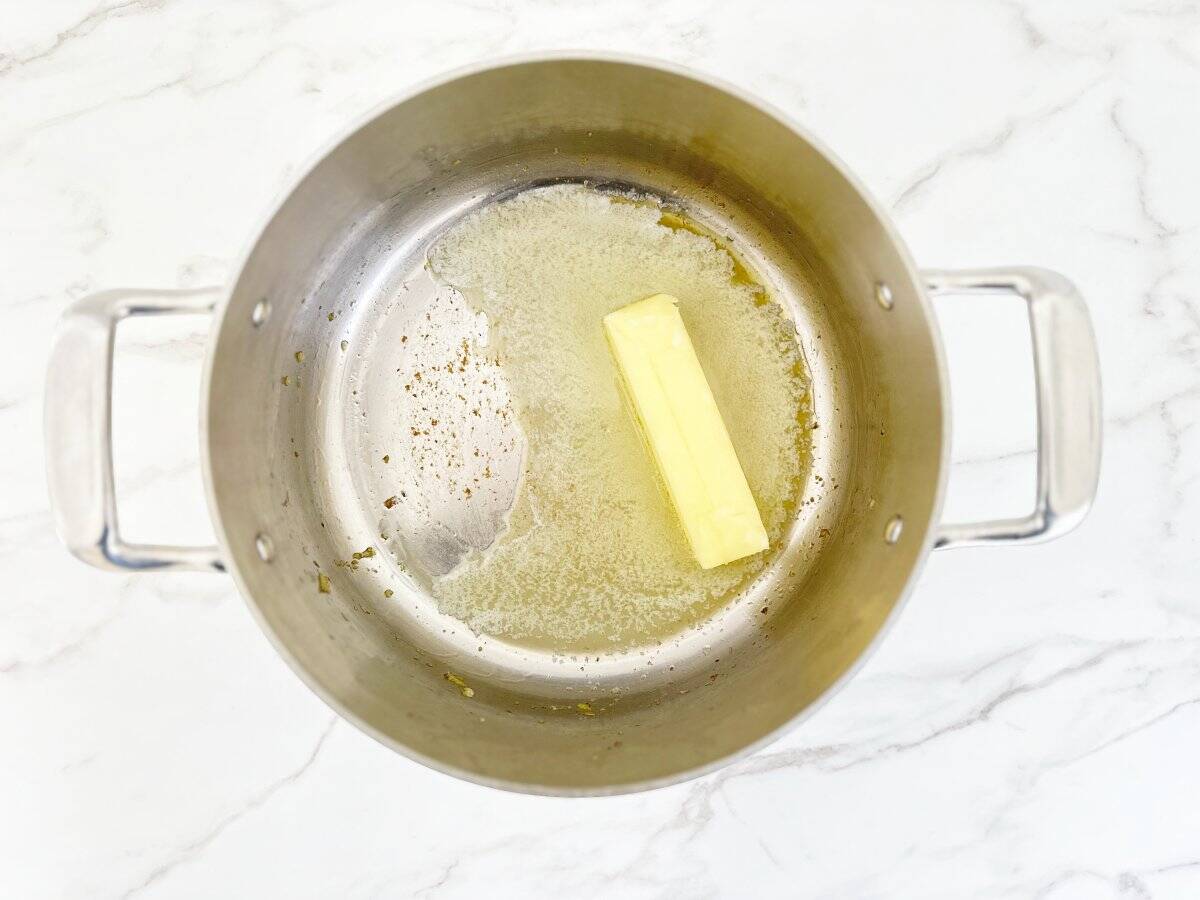 Down view of stick of butter in silver pot.