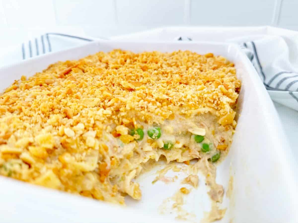 Side view of creamy tuna noodle casserole in white baking dish