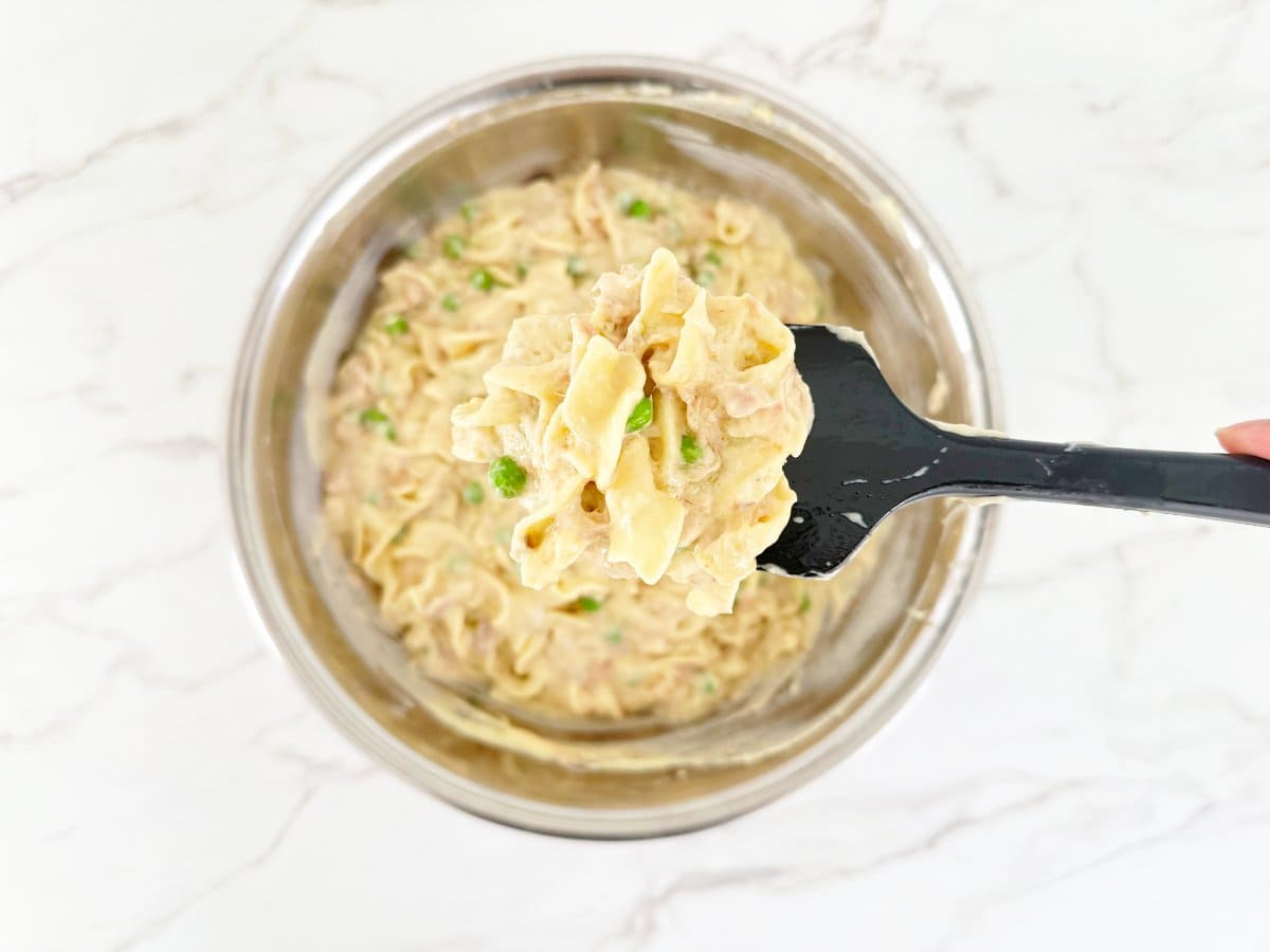 Down view of tuna casserole mixture on black rubber spatula.
