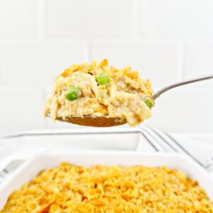 Serving spoon holding a portion tuna noodle casserole from scratch.
