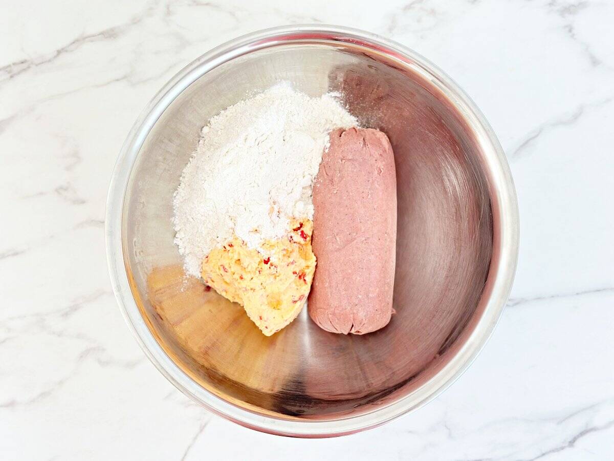 Down view of mixing bowl with 3 ingredients. Pimento cheese, sausage, and bisquick.