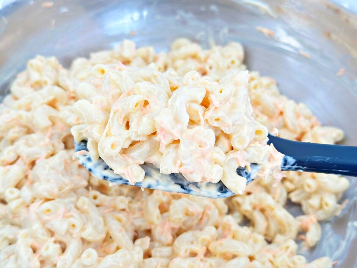 Down view of creamy macaroni salad on black rubber spatula.