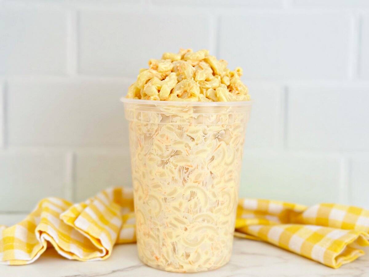 Side view of Hawaiian macaroni salad in deli container.