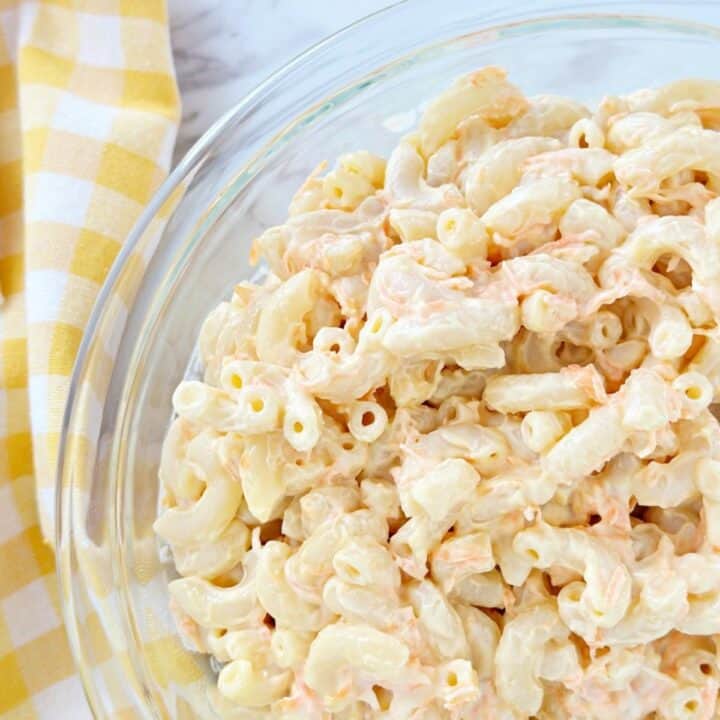 Down view of creamy Hawaiian macaroni salad in clear glass bowl.