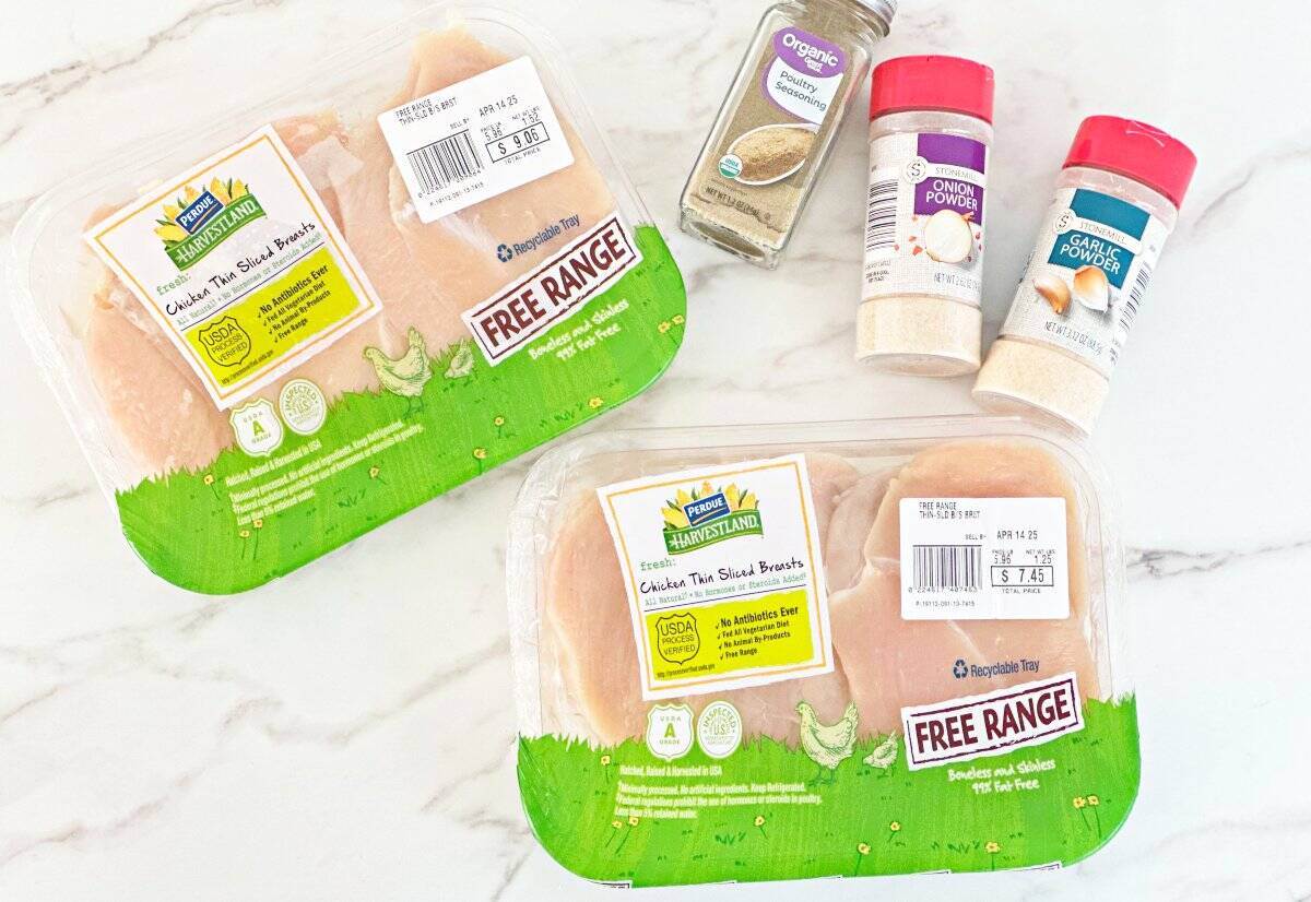 Down of spices and raw chicken breasts in their packaging.