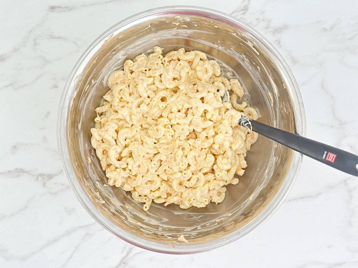 Down view of macaroni salad in silver mixing bowl.
