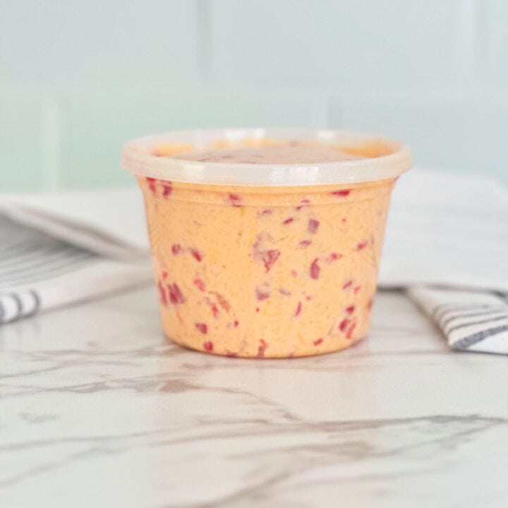Side view of pimento cheese in deli container.