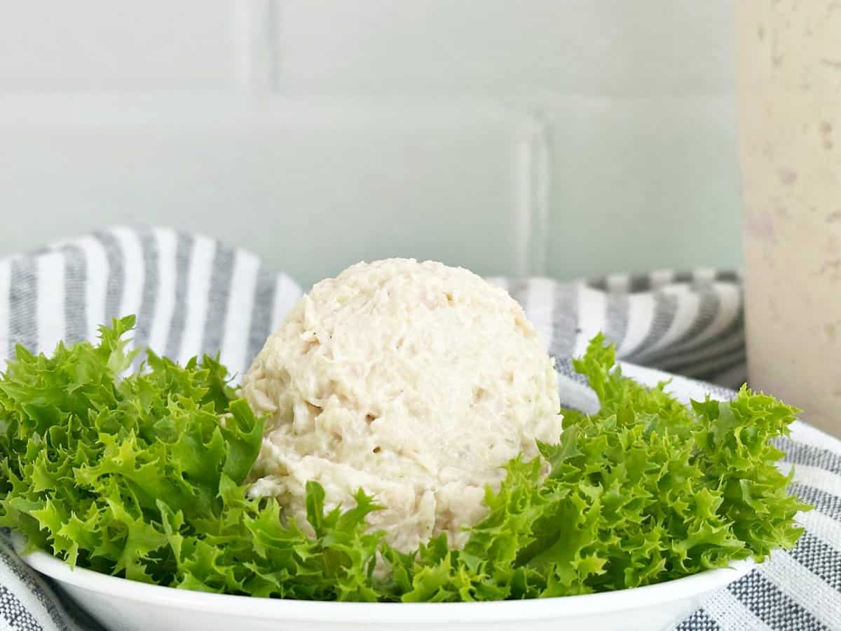 Scoop of deli chicken salad on a bed of lettuce.
