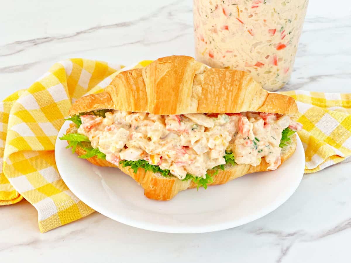 Close up view of seafood salad croissant sandwich with lettuce