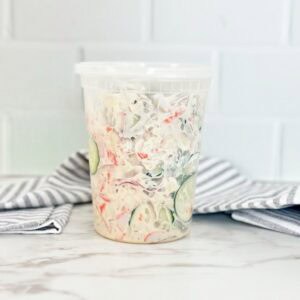 Side view of viral TikTok sushi cucumber salad in deli container.