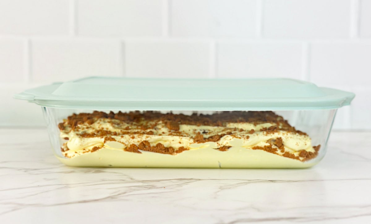 Covered deep casserole dish with peach cobbler pudding.