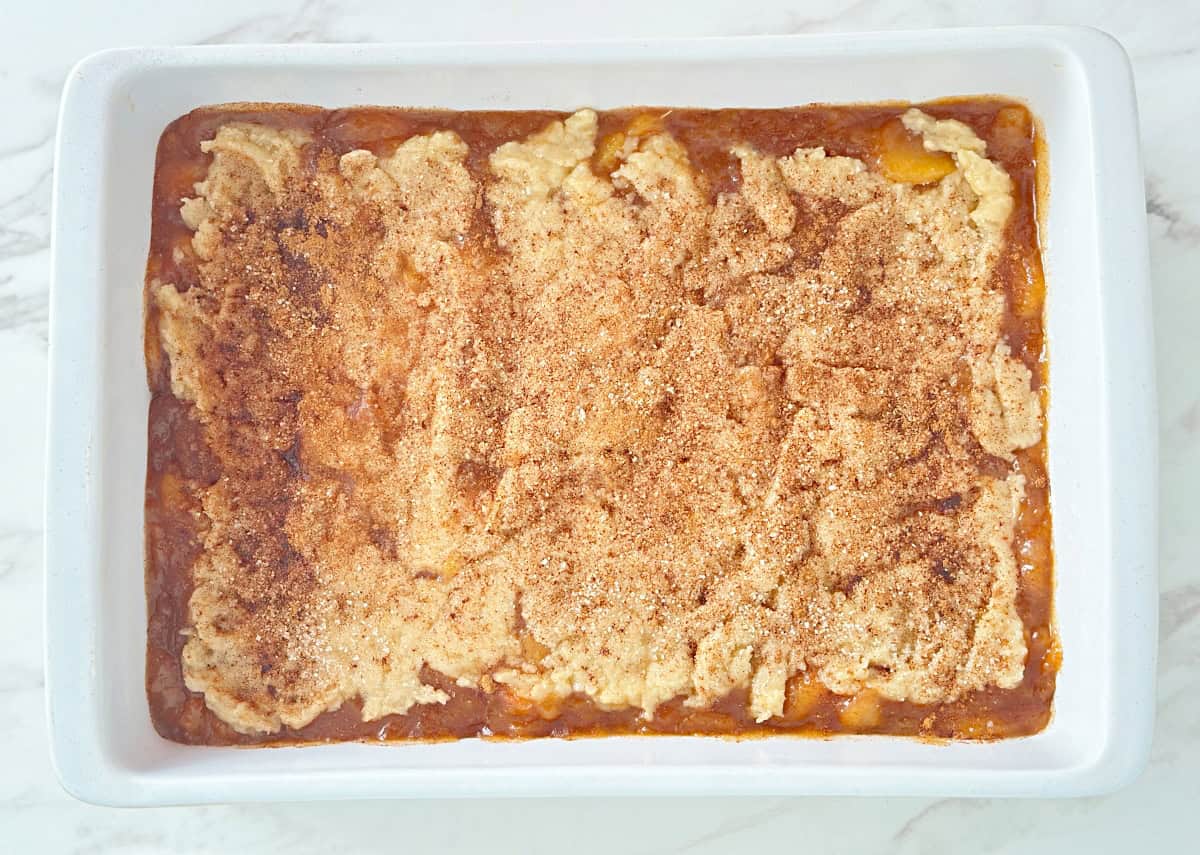 Down view of unbaked old fashioned peach cobbler.