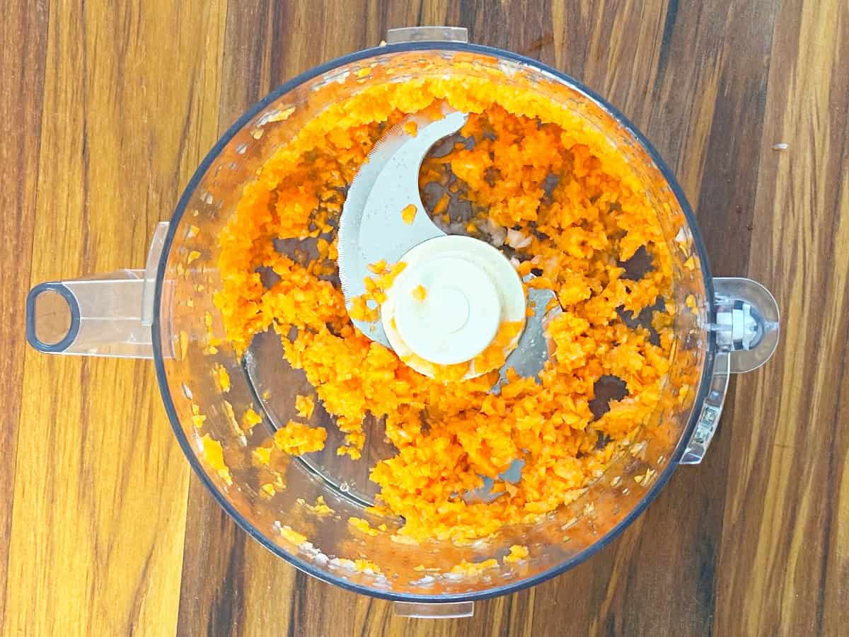 Down view of food processor jar with chopped carrots.
