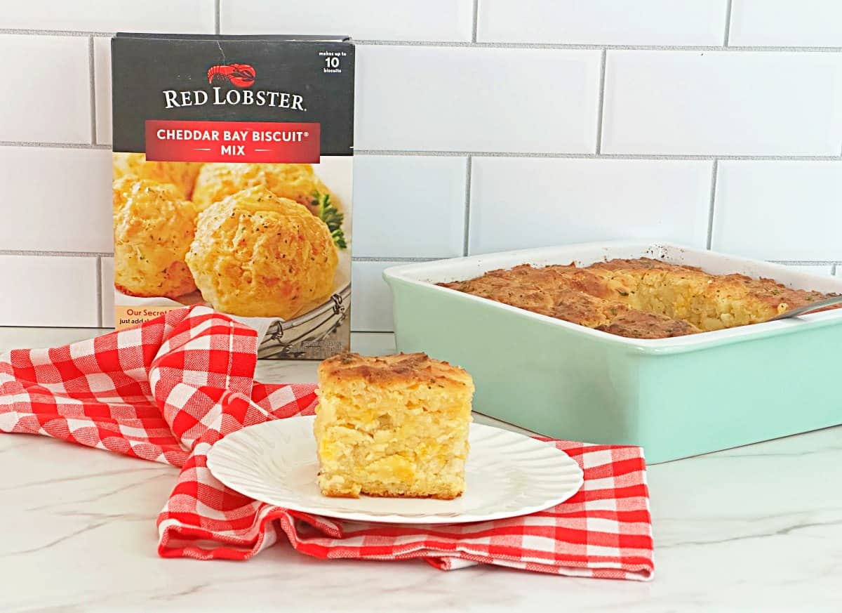 Cheddar bay butter swim biscuit on a white plate. Next to a box of Red Lobster cheddar bay biscuit mix.