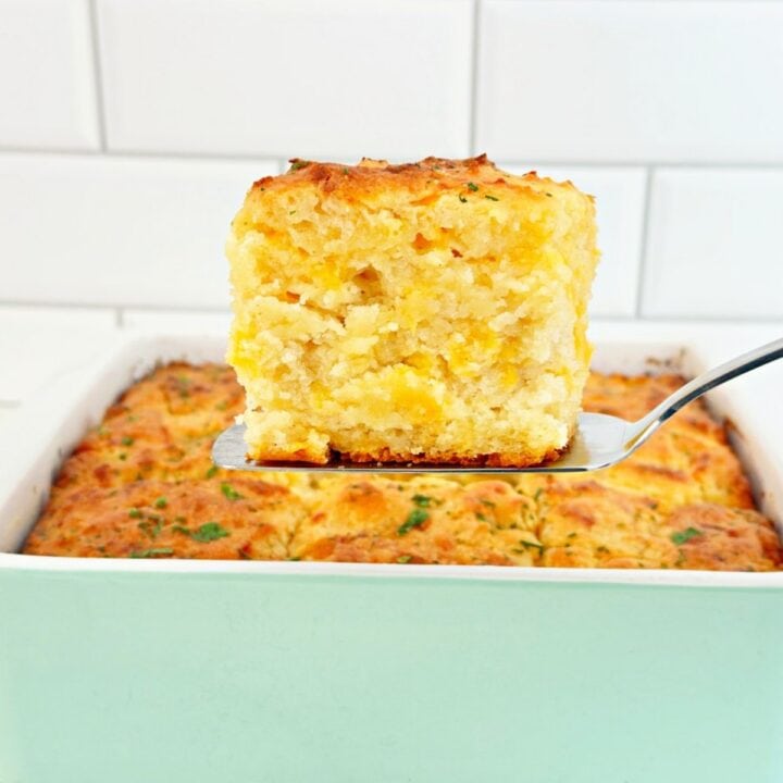 Silver spatula holding a cheddar bay butter swim biscuit.