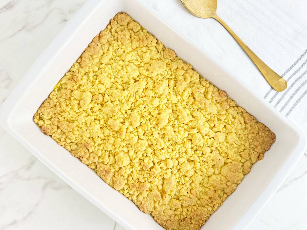 Down view of easy lemon crumble cobbler with cake mix topping in a white baking dish.