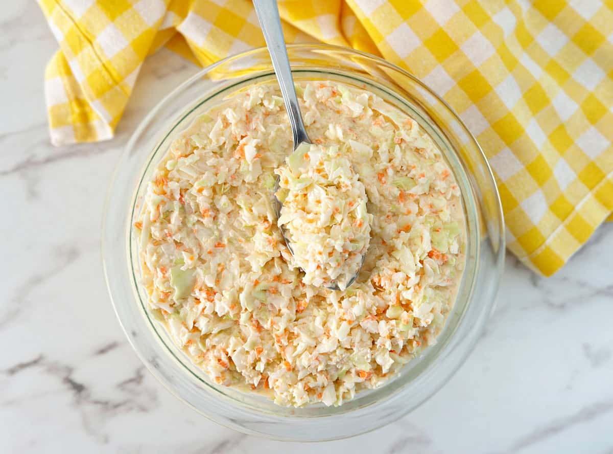 A bowl of easy southern coleslaw and a silver serving spoon.