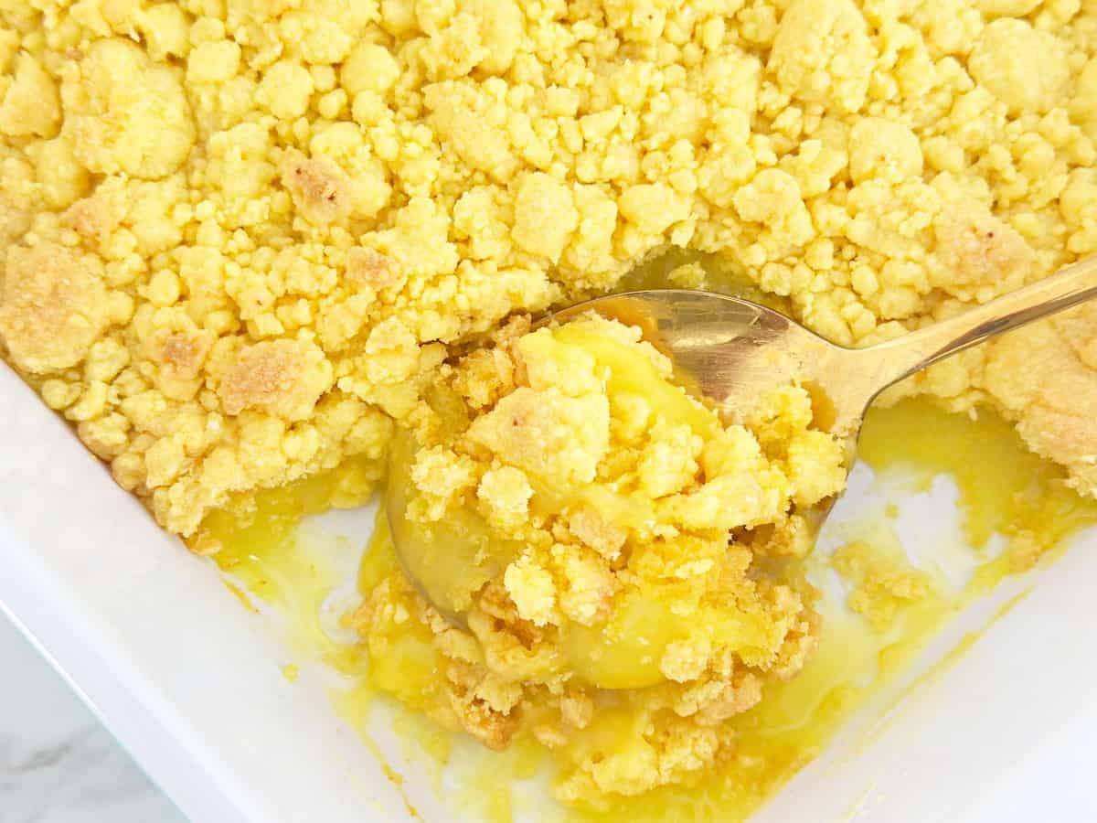 Lemon crumble on a gold serving spoon. Shows gooey texture.