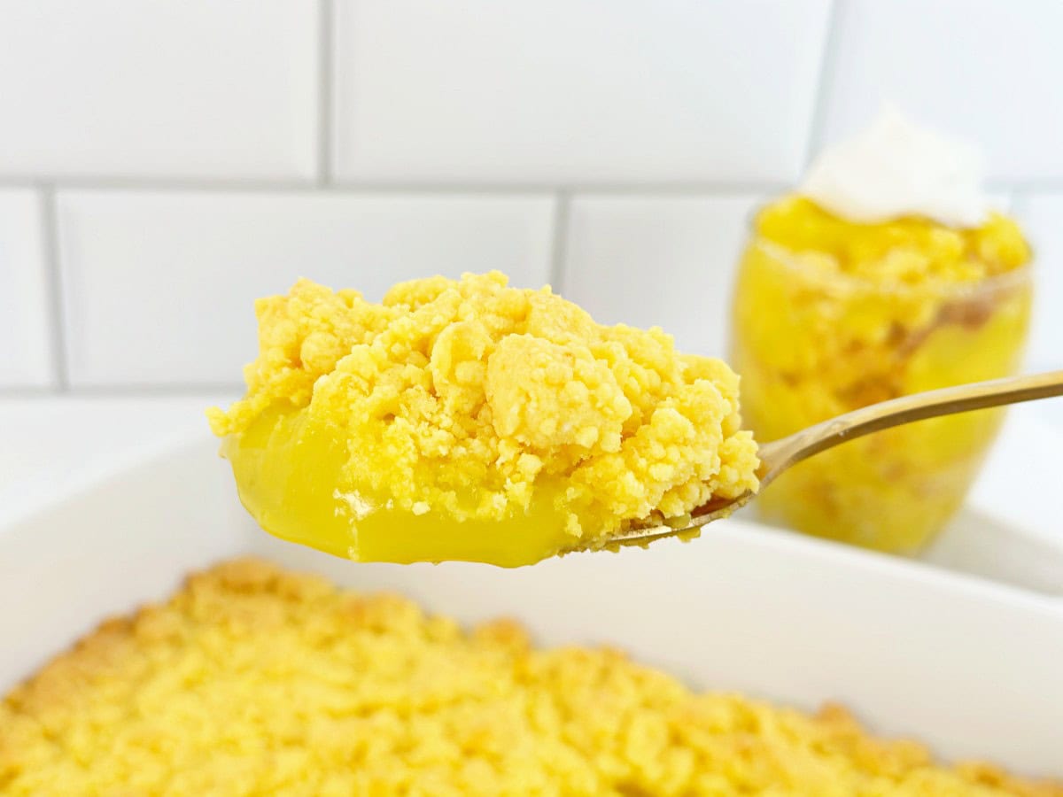 Lemon crumble with cake mix on a gold serving spoon.