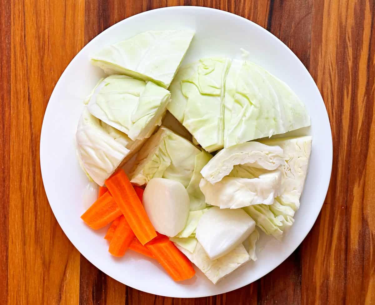 White plate with chunks of cabbage, carrots, and onion.