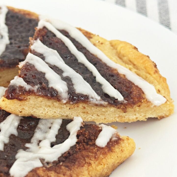 A slice of cinnamon sugar dessert pizza on a white plate, close up side view.