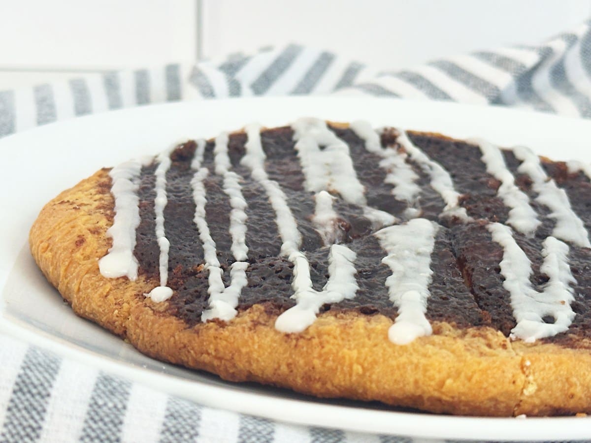 Cinnamon sugar dessert pizza on a white plate, close up side view.