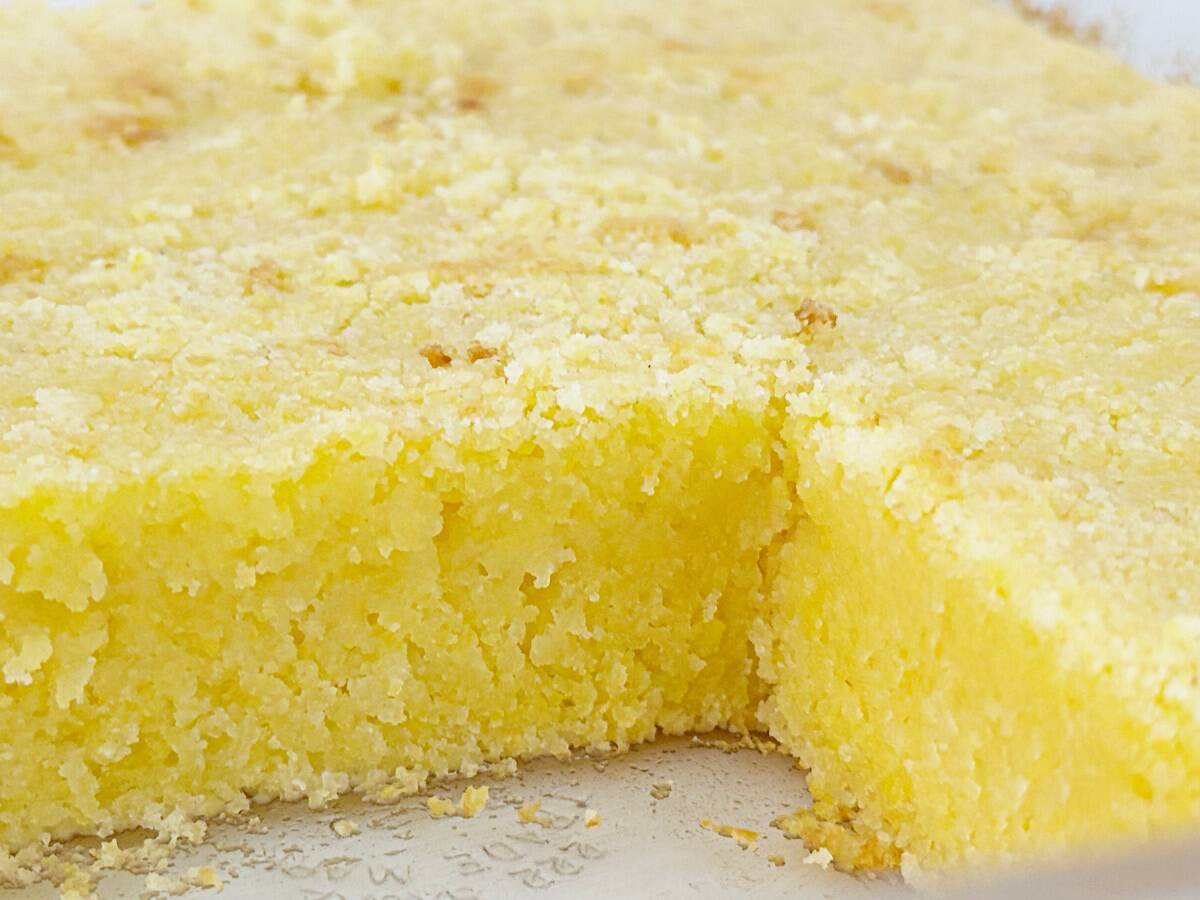 Cut Jiffy cornbread in a baking dish, close-up view to show the moist texture.