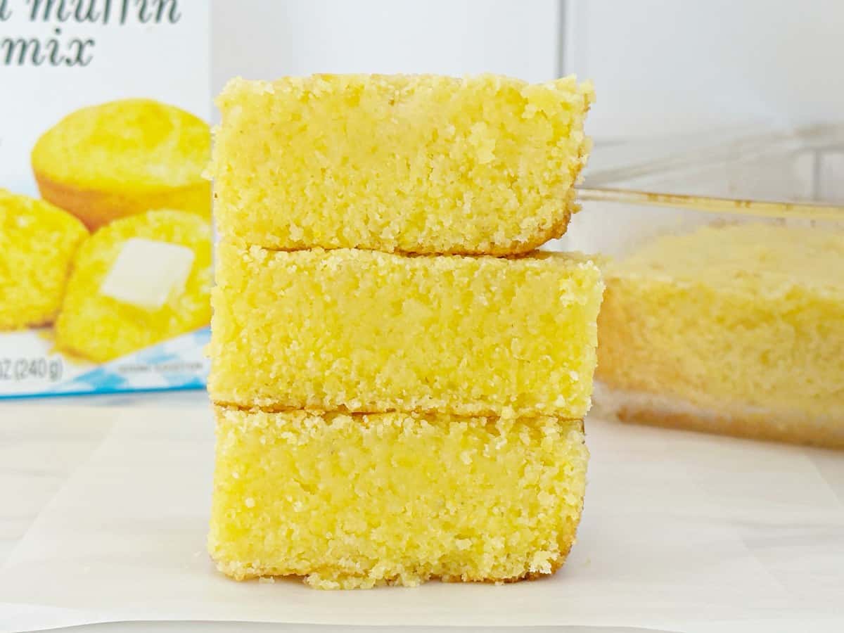 Three Jiffy buttermilk cornbread pieces stacked, close-up side view.